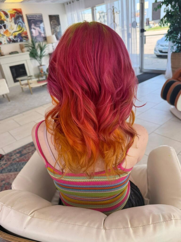 Sunset pink orange hair color with creative placement